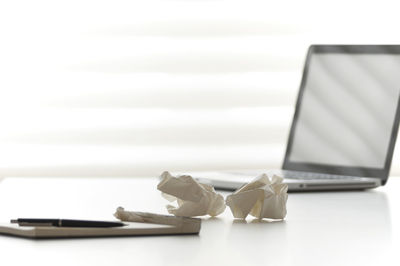 Close-up of laptop on paper against white background