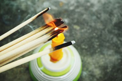 High angle view of incense sticks burning from candle