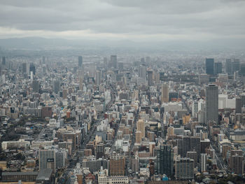 Aerial view of buildings in city against sky