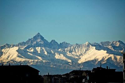 Scenic view of snowcapped mountains against clear blue sky