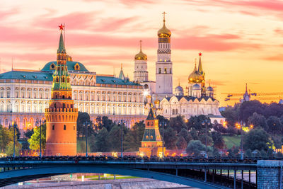 Buildings in city against sky during sunset