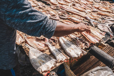 Midsection of man selling fish on market stall