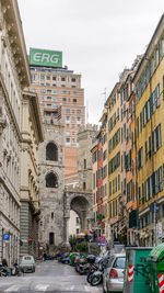 Road amidst buildings in city against sky