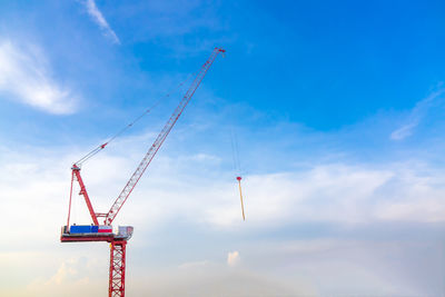 Low angle view of crane against sky