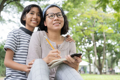 Portrait of a smiling young woman using mobile phone