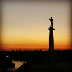 Statue against sky at sunset