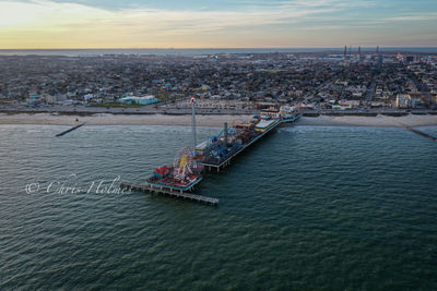 High angle view of cityscape by sea against sky