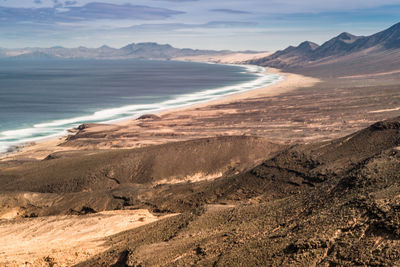 Scenic view of sea and mountains against sky