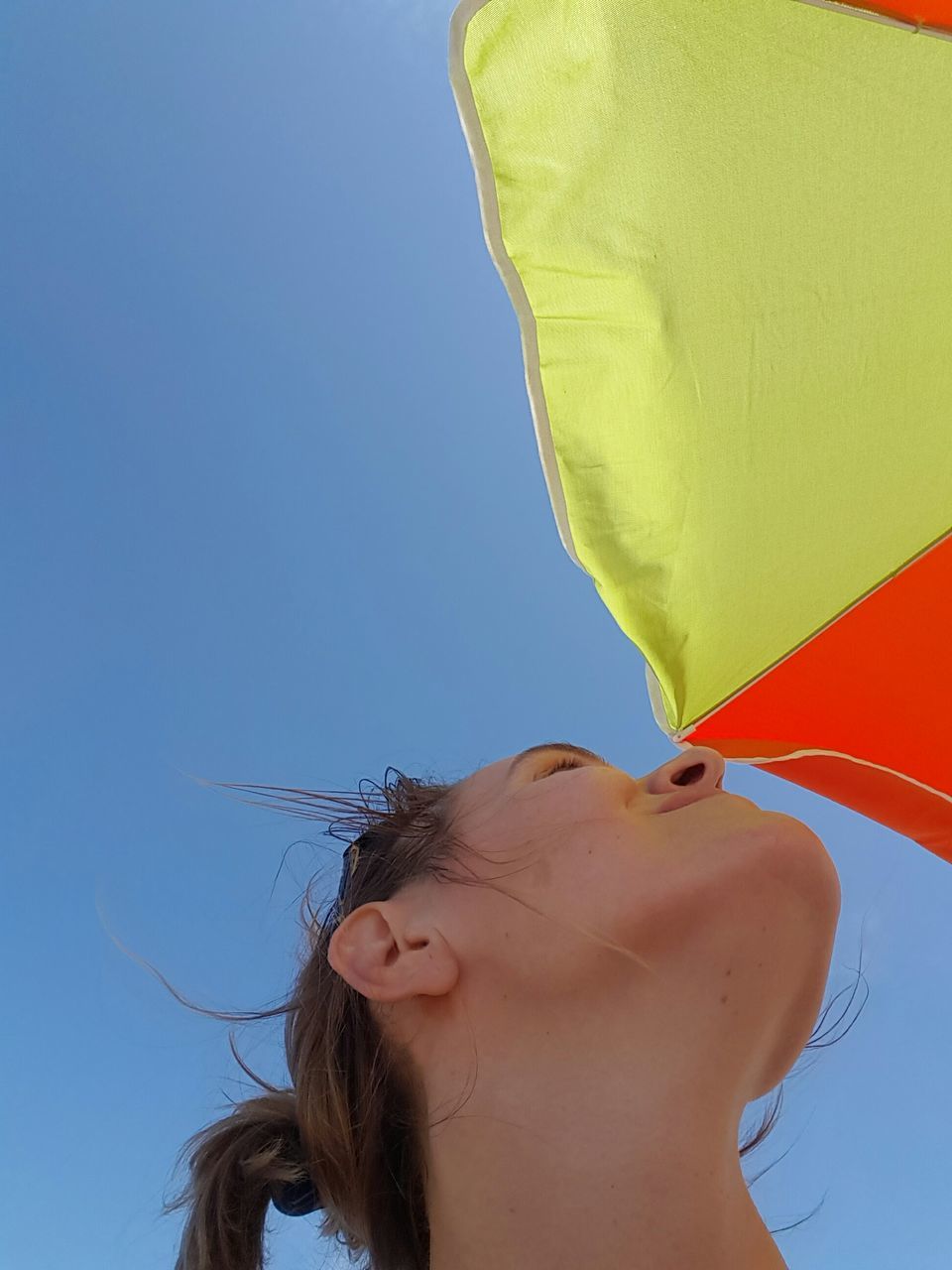 headshot, clear sky, lifestyles, young adult, leisure activity, low angle view, person, close-up, copy space, part of, young women, front view, blue, head and shoulders, human face, cropped, portrait