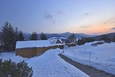 Scenic view of snow covered mountains against sky during sunset