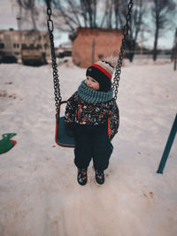 Rear view of woman swinging at playground