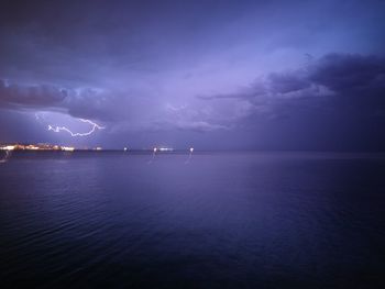 View of lightning strike against calm sea