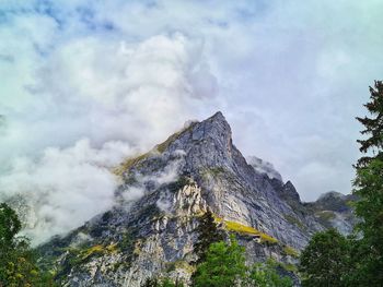 Low angle view of rocky mountains against sky