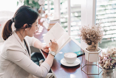 Woman holding coffee cup on table