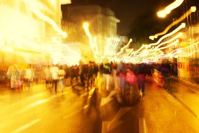 People walking on city street at night