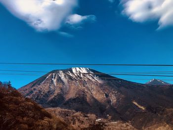 Low angle view of mountain against blue sky