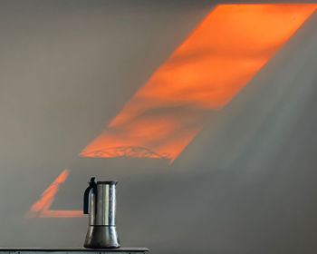 Close-up of fire on table against sky during sunset