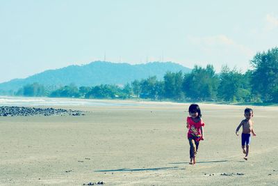 Rear view of women walking on beach