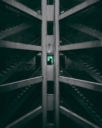 Low angle view of a structural architecture with silhouette of a man in green light