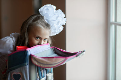 Portrait of cute girl packing bag at home