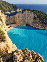 Rock formation against sea in sunny day