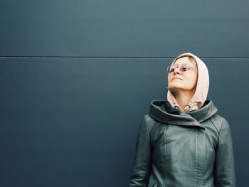 Young woman standing against wall