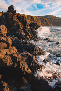 Rock formation in sea against sky