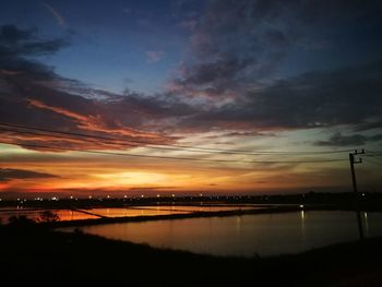 Scenic view of river against sky at sunset