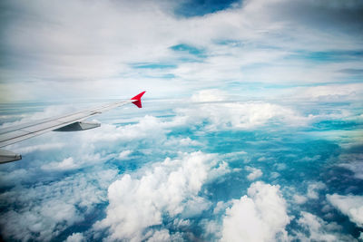 Airplane flying over cloudscape against sky