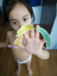 Portrait of cute boy holding baby at home