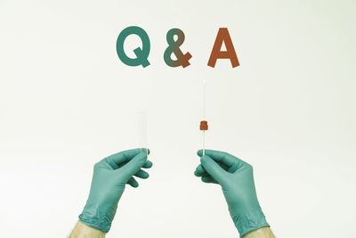 Low angle view of hand holding paper against white background