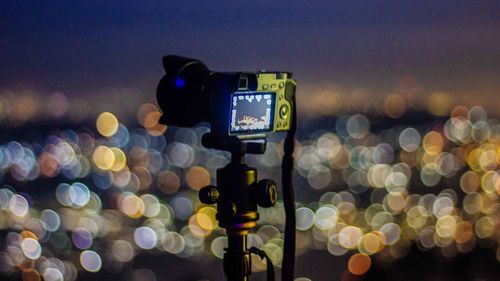 Close-up of illuminated lighting equipment in city at night