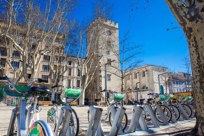 Bicycles by street against buildings in city