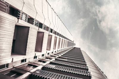 Low angle view of modern building against cloudy sky