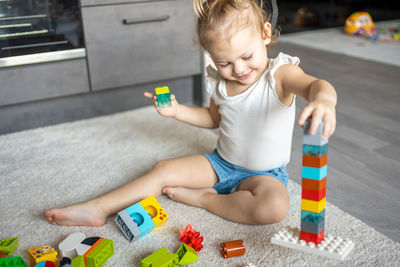 Cute girl playing with multi colored toy at home