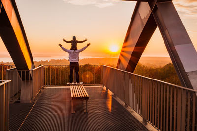 Rear view of woman standing on bridge