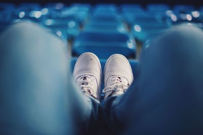 Low section of man sitting on chair at stadium