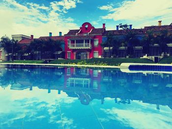 Reflection of trees in swimming pool against sky