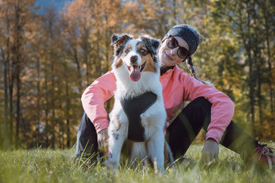 Candid portrait of female athlete with her running and hiking partner, an australian shepherd dog
