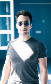 Portrait of young man wearing sunglasses standing outdoors