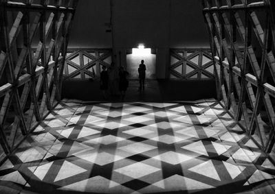 Silhouette man standing on illuminated walkway