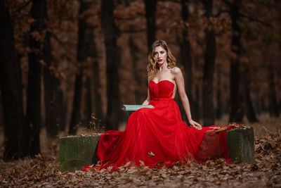 Portrait of woman with red umbrella in forest