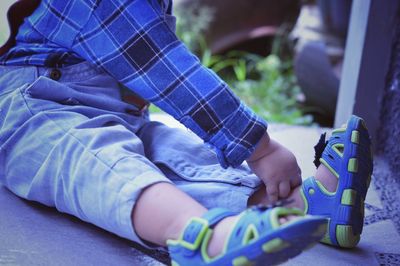 Low section of boy wearing shoes