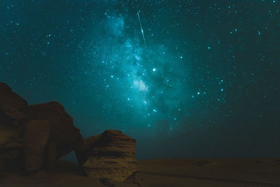 Scenic view of rock formation against star field at night