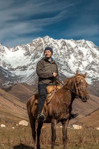 Rear view of man riding horse on mountain