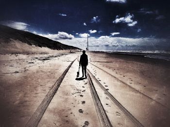 Rear view of woman standing on beach