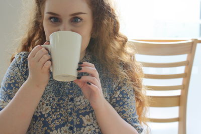 Portrait of woman drinking coffee at home