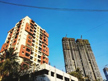 Low angle view of skyscrapers against clear blue sky