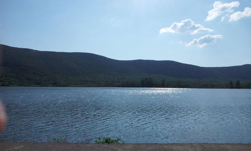 Scenic view of lake by mountains against sky