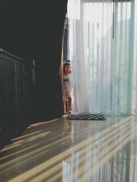 Girl seen through curtain at home